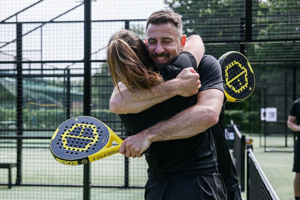 Man and woman huging after Padel match