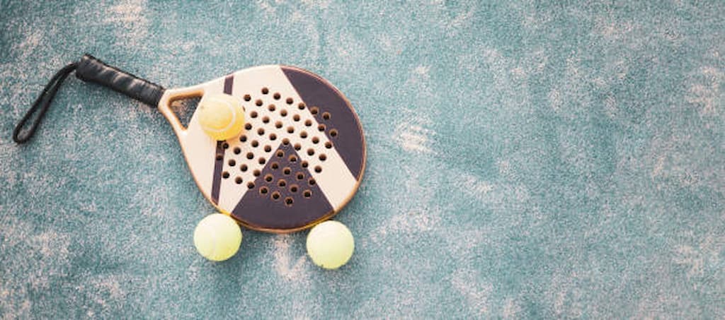 Padel racket on Padel court with balls